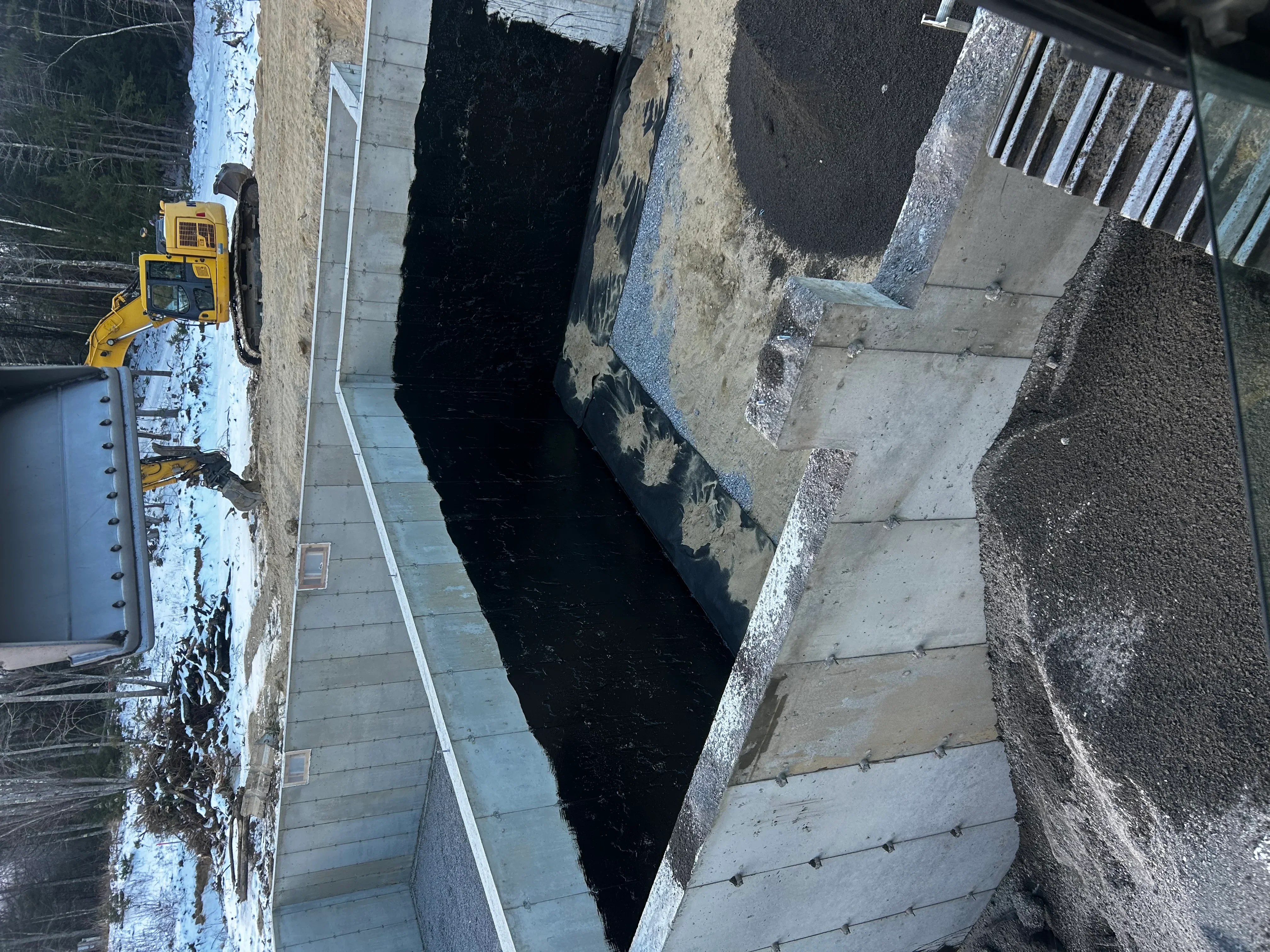 Excavated asphalt driveway removal with heavy equipment and debris staging