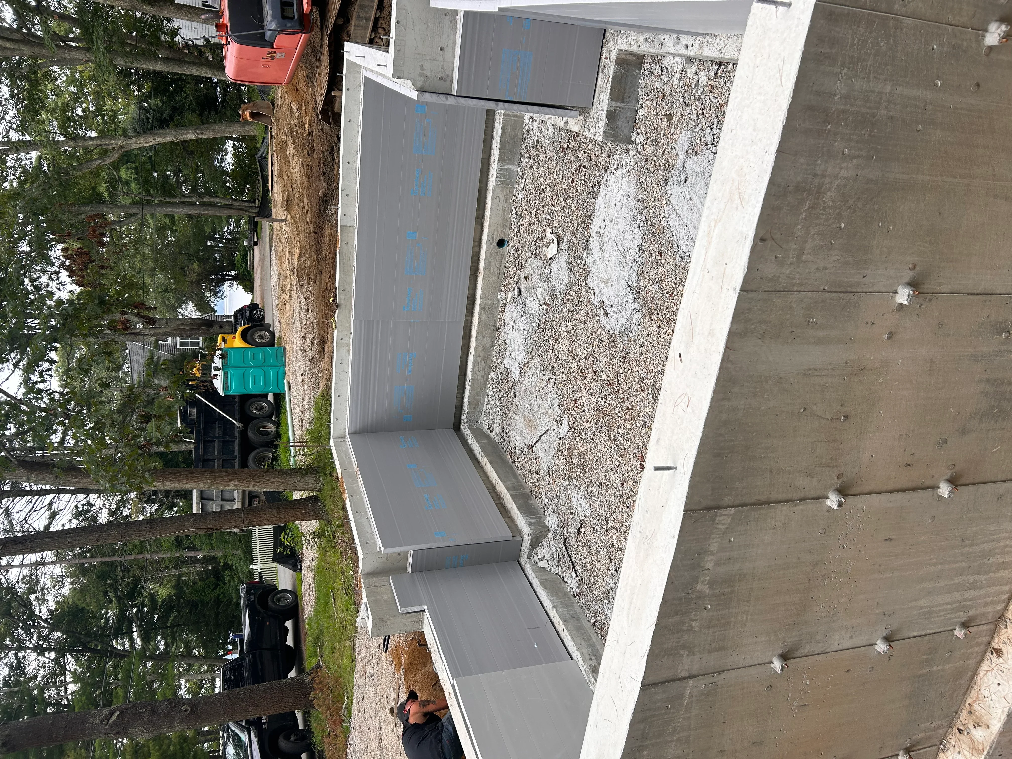 Residential driveway excavation with gravel base material and concrete edging installation
