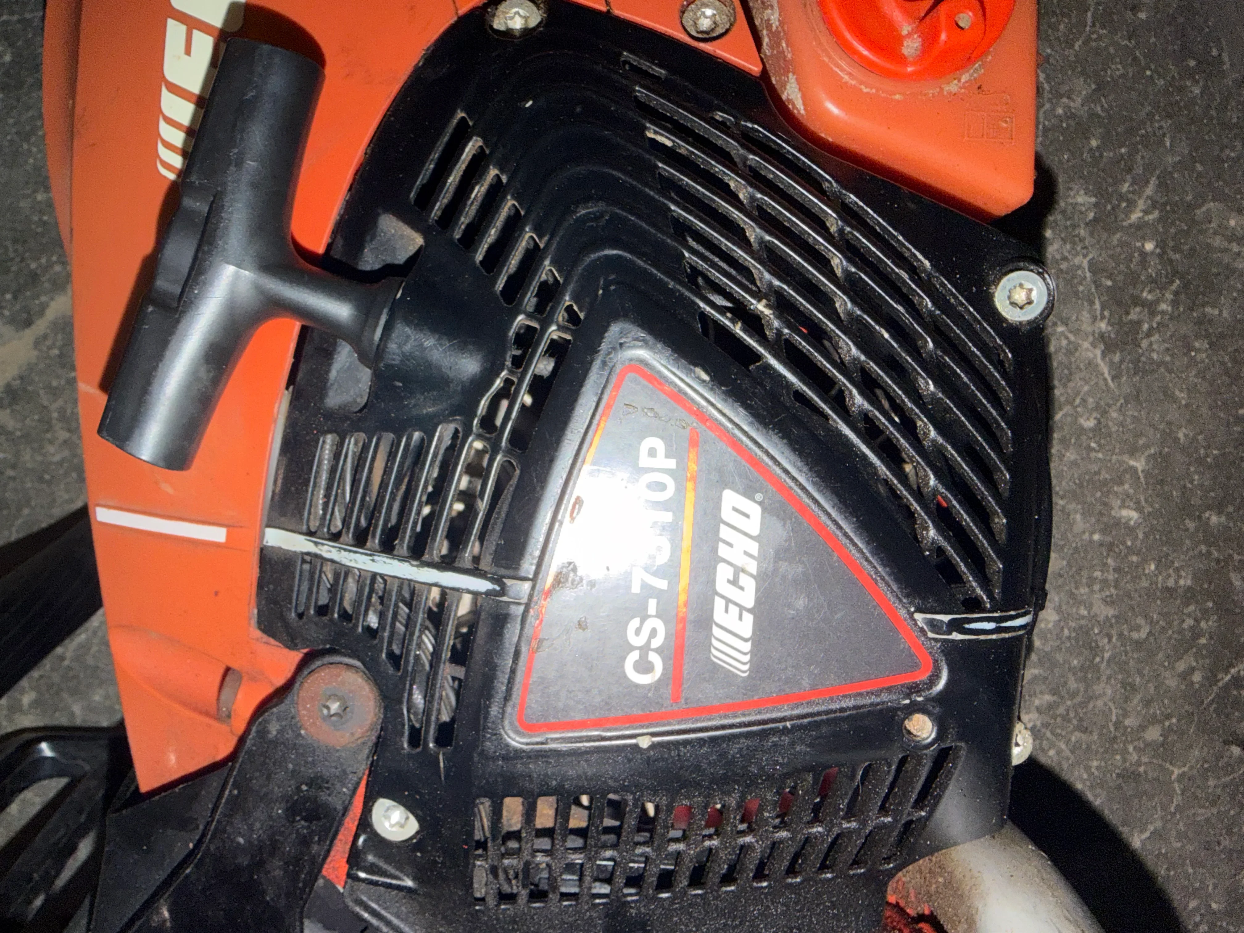 Weed Eater chainsaw engine with cooling fins and fuel cap on orange equipment frame