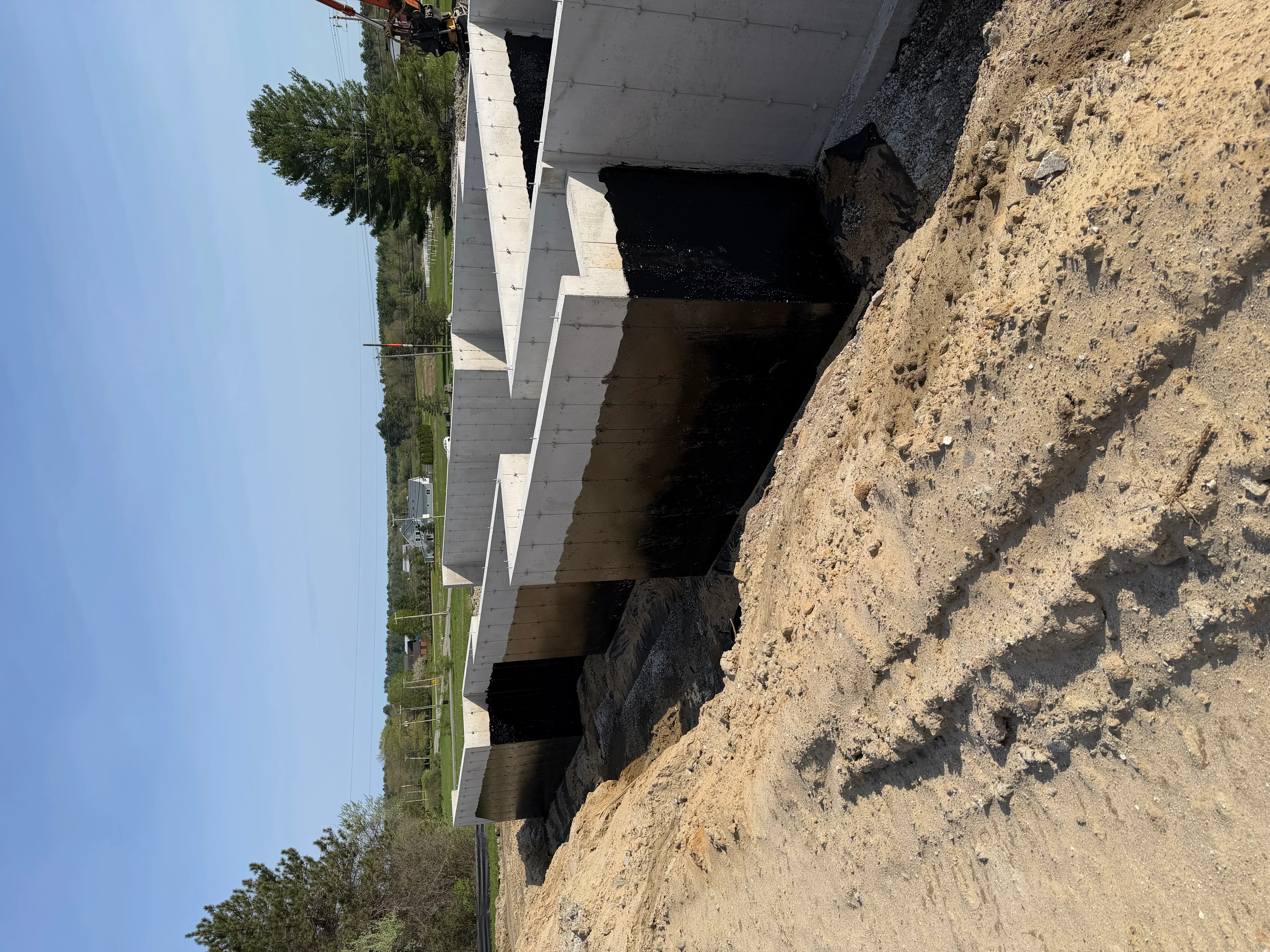 Concrete culvert structure installed in excavated earth embankment with staged materials